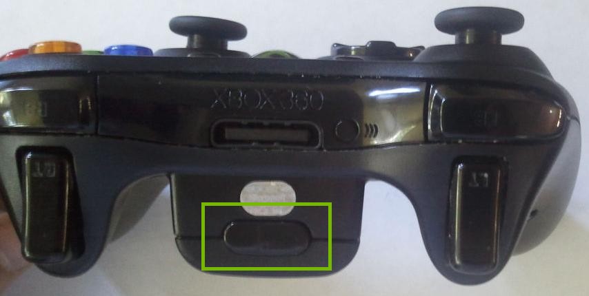 Xbox 360 wireless controller highlighting the battery compartment release button.
