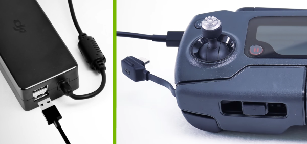 USB cable plugged into drone battery charger and remote control.