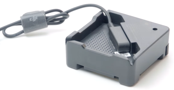 Charging cable plugged in drone battery charging hub.