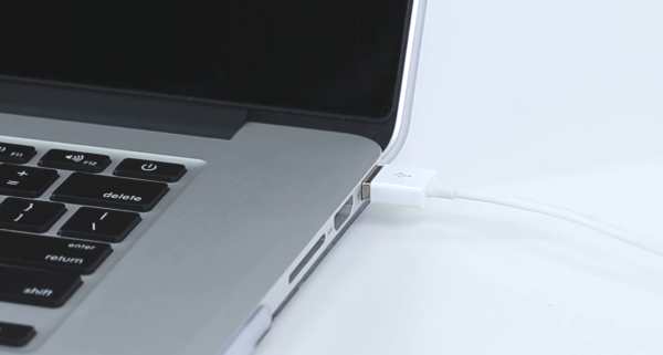 USB cable being plugged into computer.