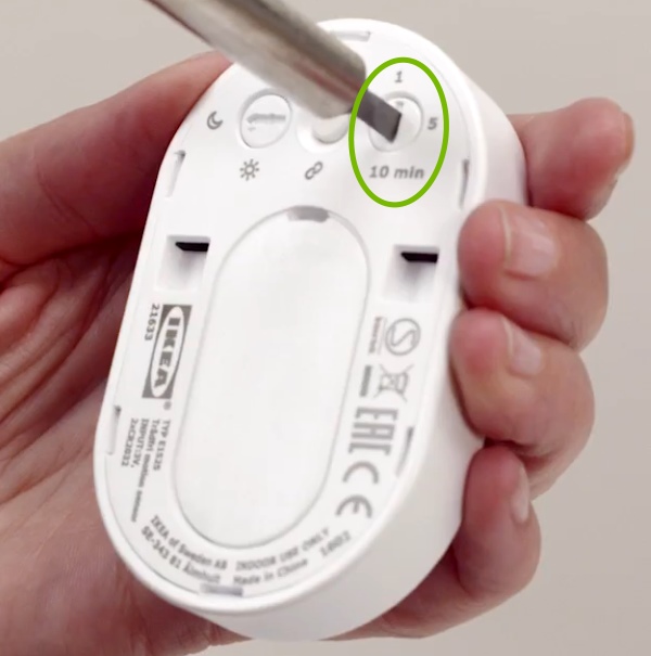 Time setting being adjusted with screwdriver on rear of IKEA Tradfri motion sensor.