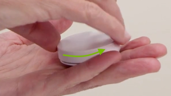 IKEA Tradfri wireless dimmer cover being turned counter clockwise to be removed.