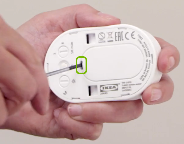 Back cover being removed from motion sensor.