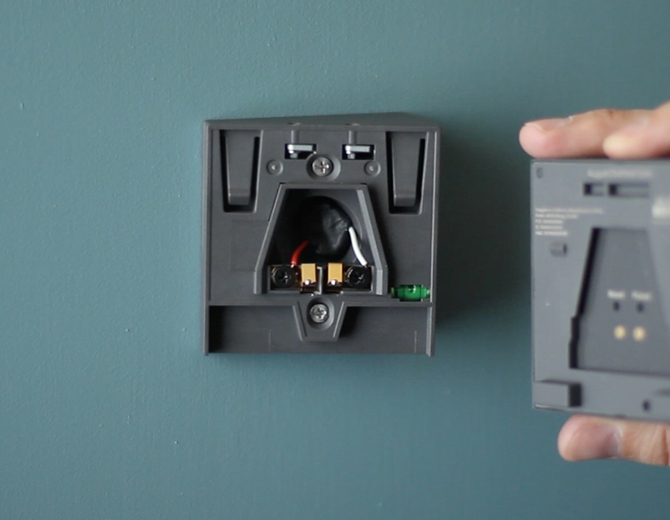 Removing the camera from the wall mount. Illustration.