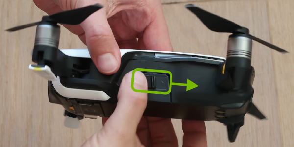 Battery side buckle highlighted and arrow pointing release direction.