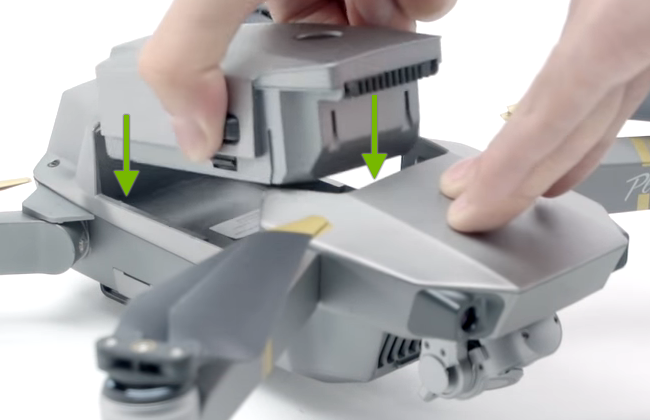 Arrows showing direction to insert battery into drone.
