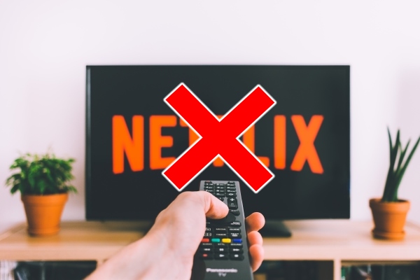 Viewer pointing remote at TV loading up Netflix.