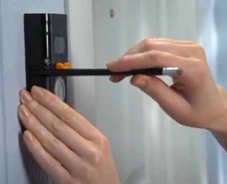 Ring doorbell against wall with pencil for marking template