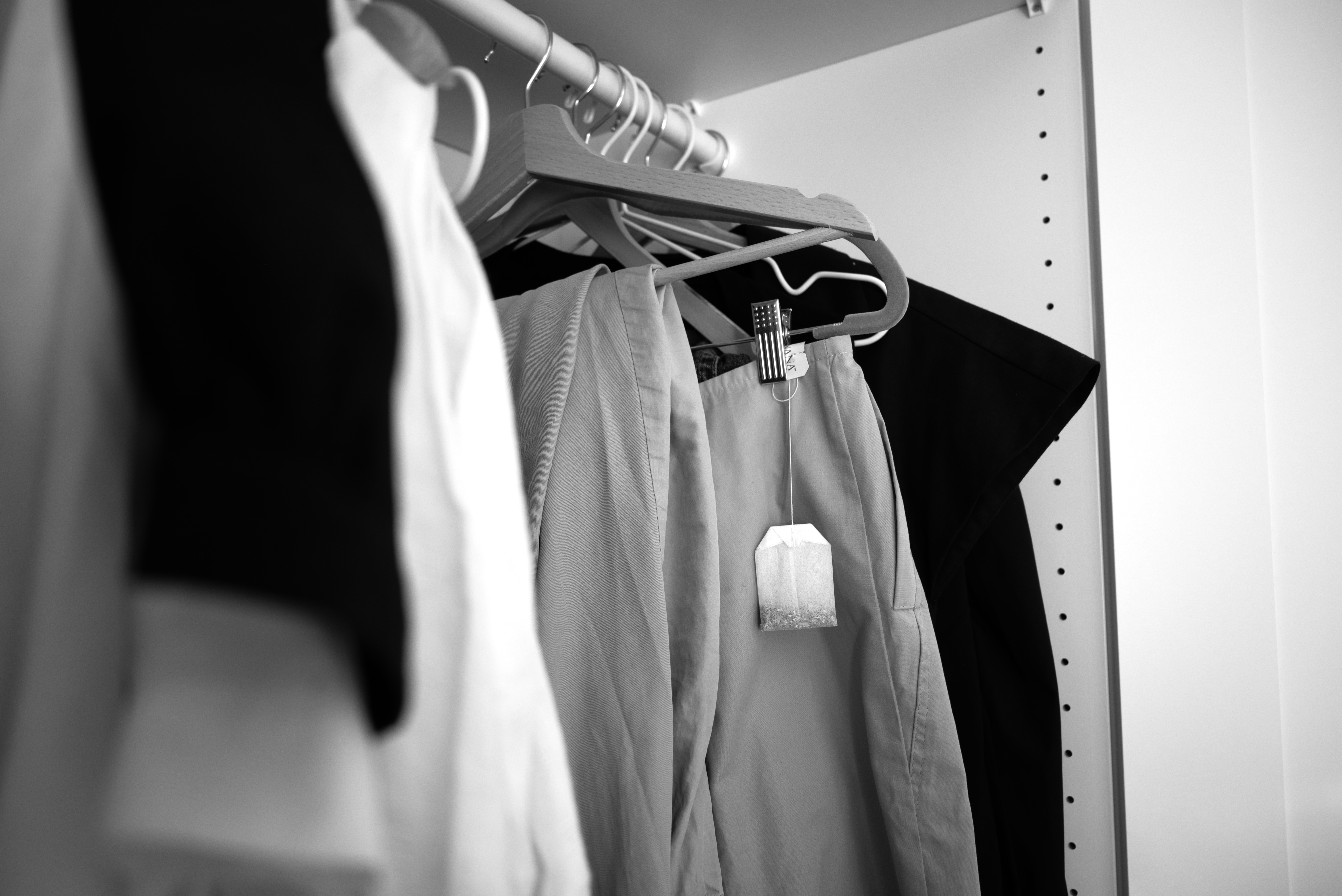 Black and White image: clothes on coat hangers and teabag hanging 