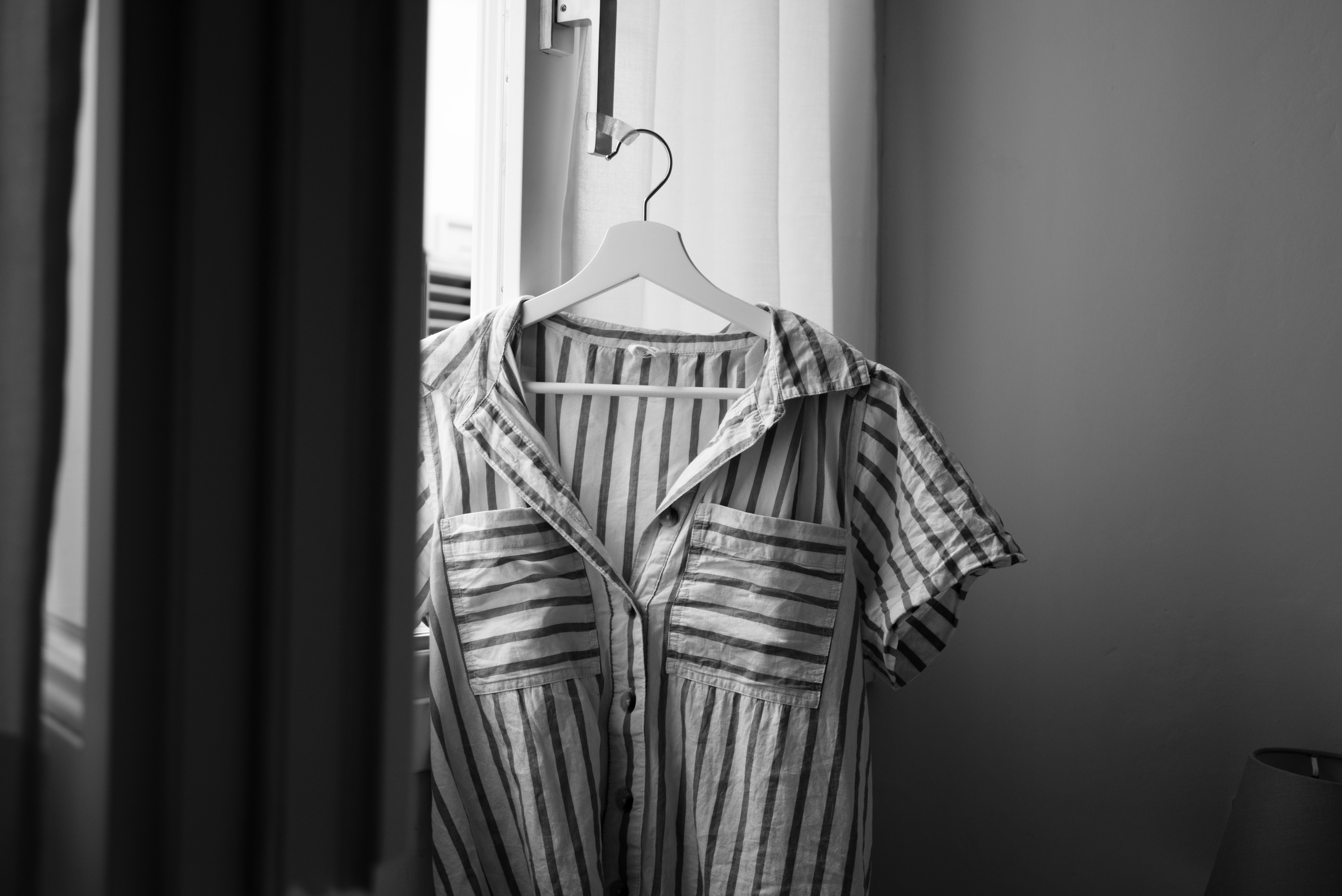 Black and White image: shirt on hanger in window 