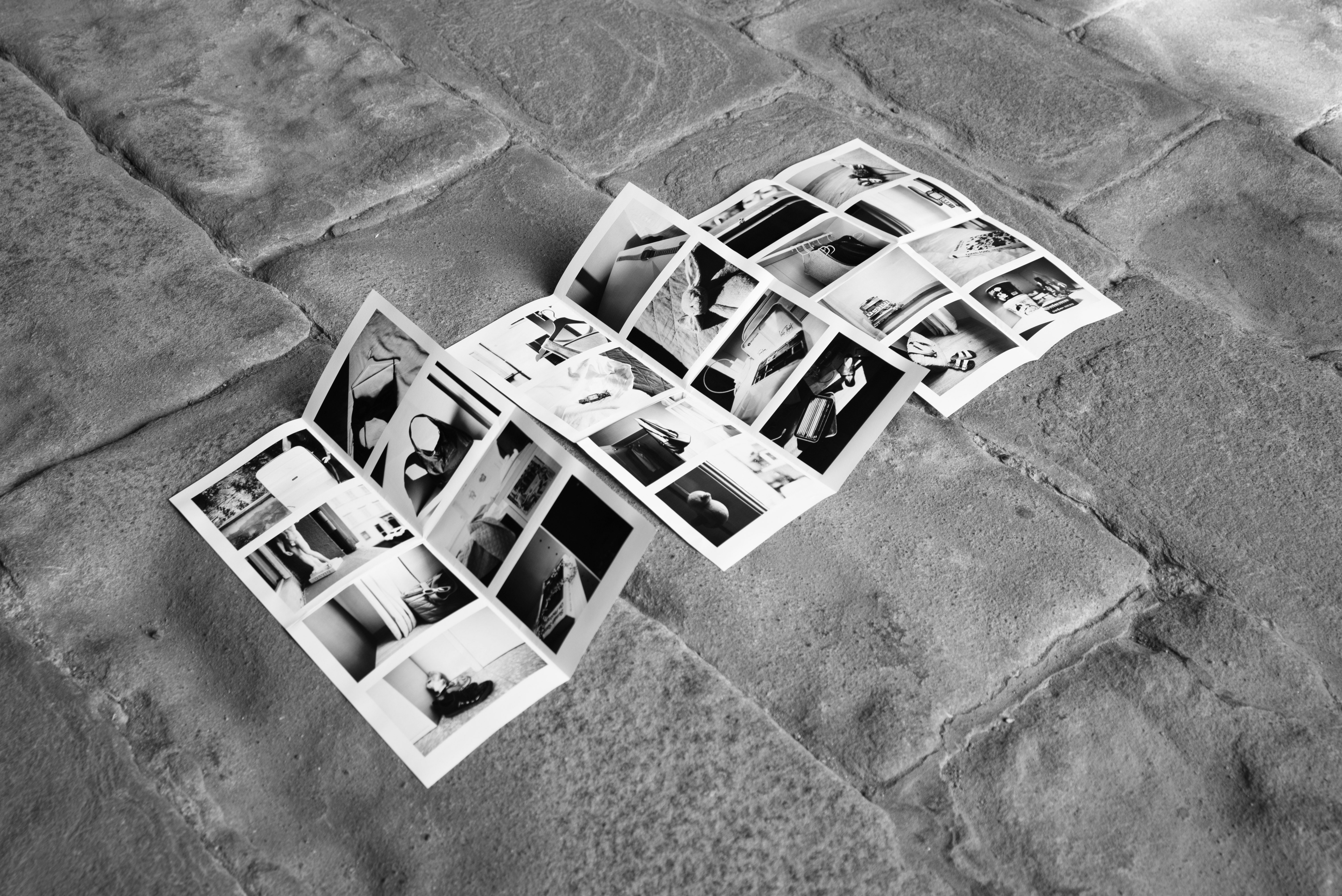 Black and White image: three brochures on concrete ground 