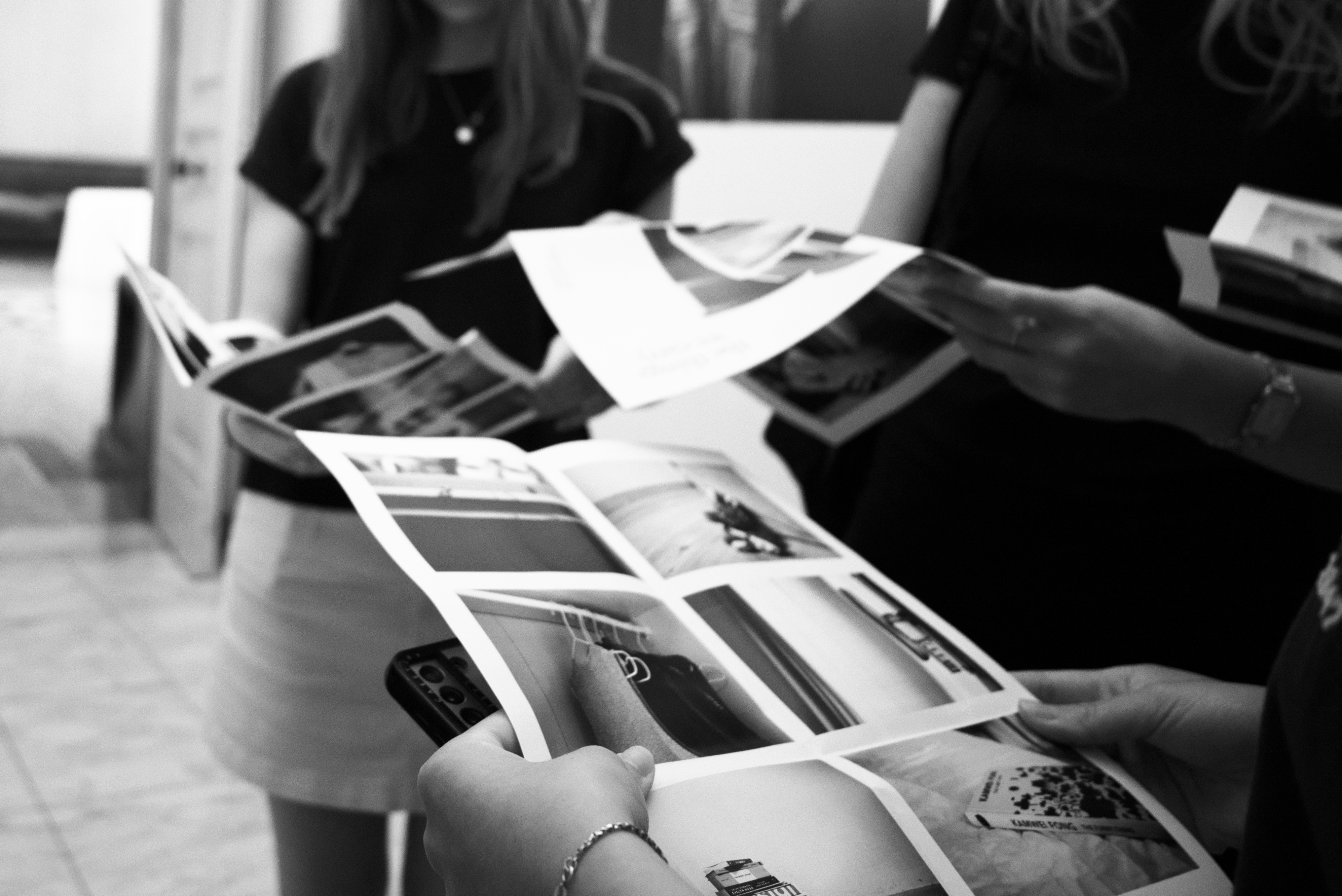 Black and White image: people holding brochures