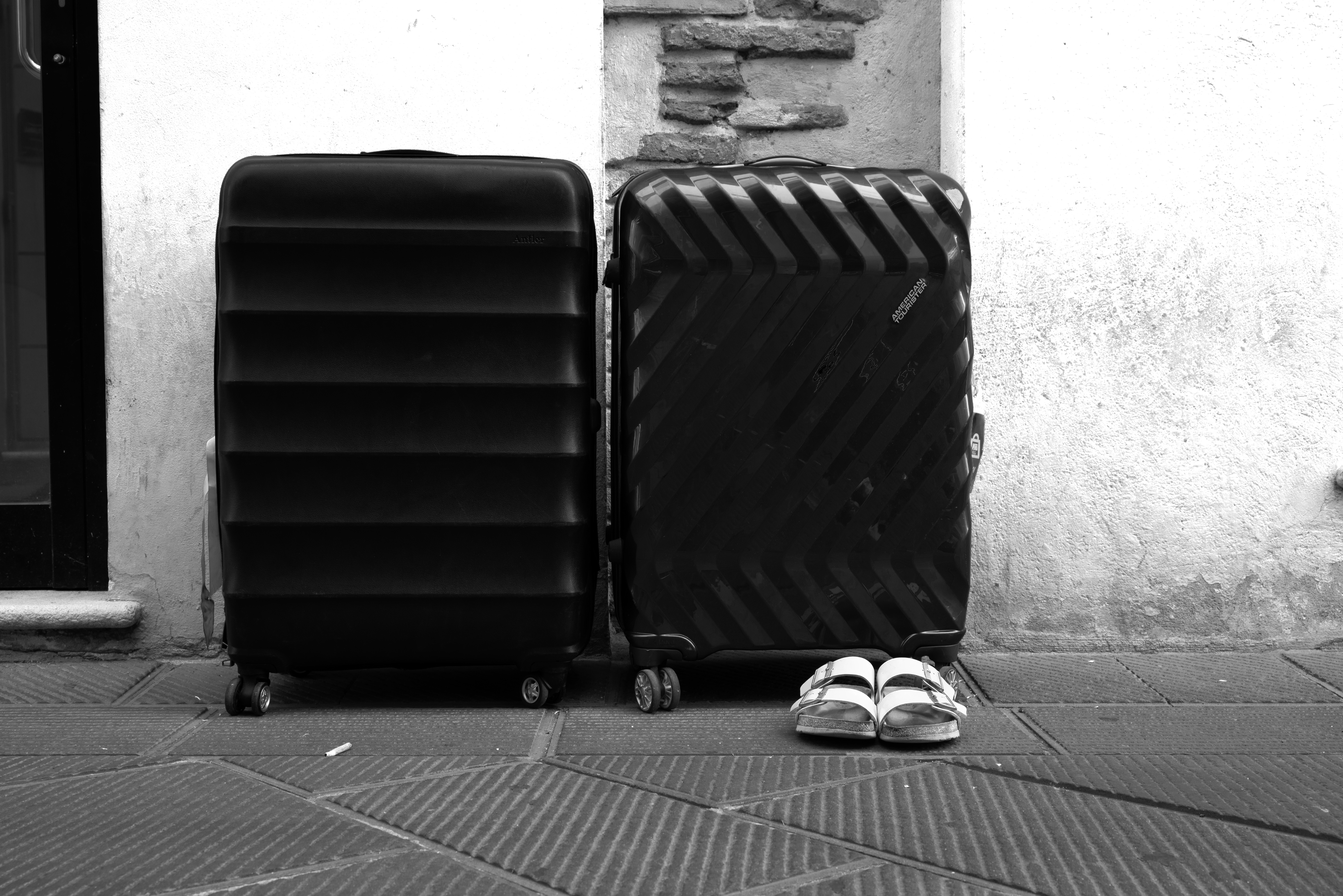 Black and White image: Two suitcases and a pair of shoes