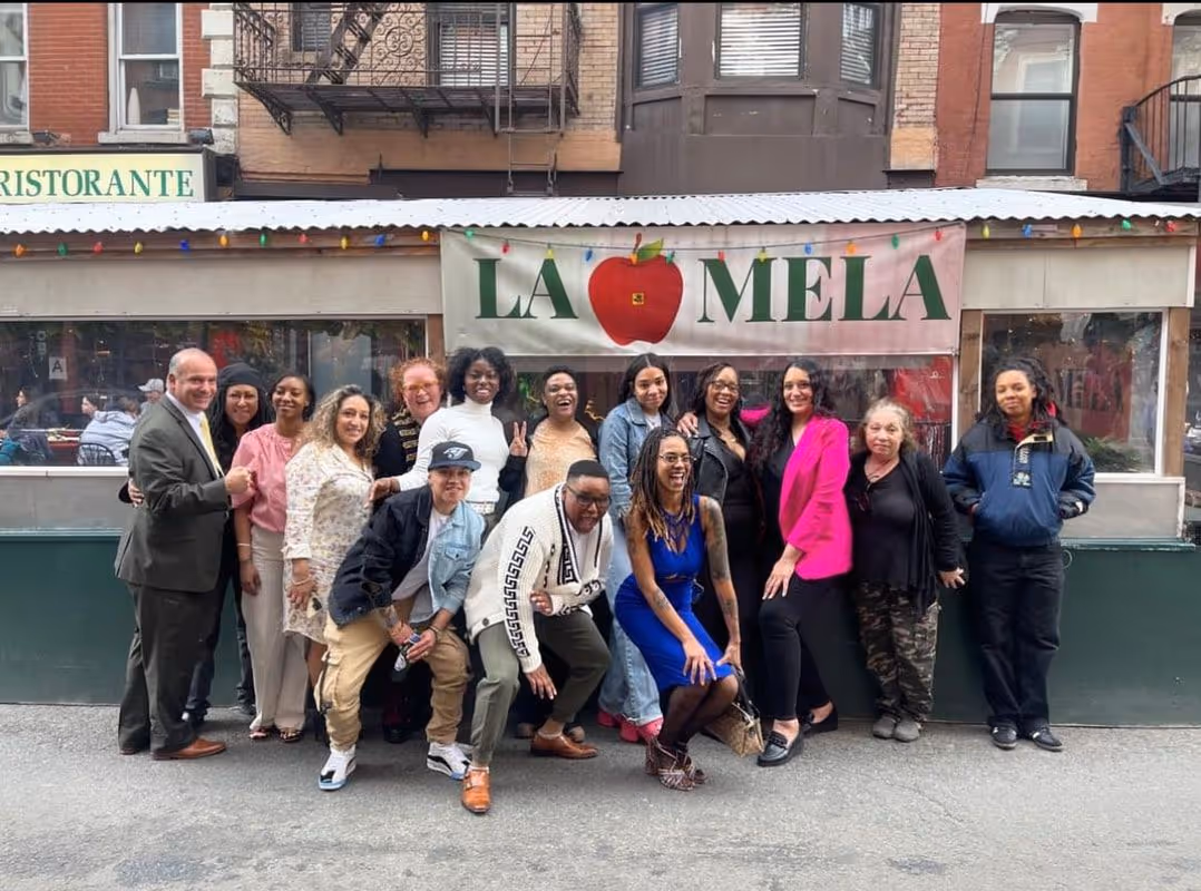 SMART Local 28 members posing together outside La Mela restaurant in New York City.