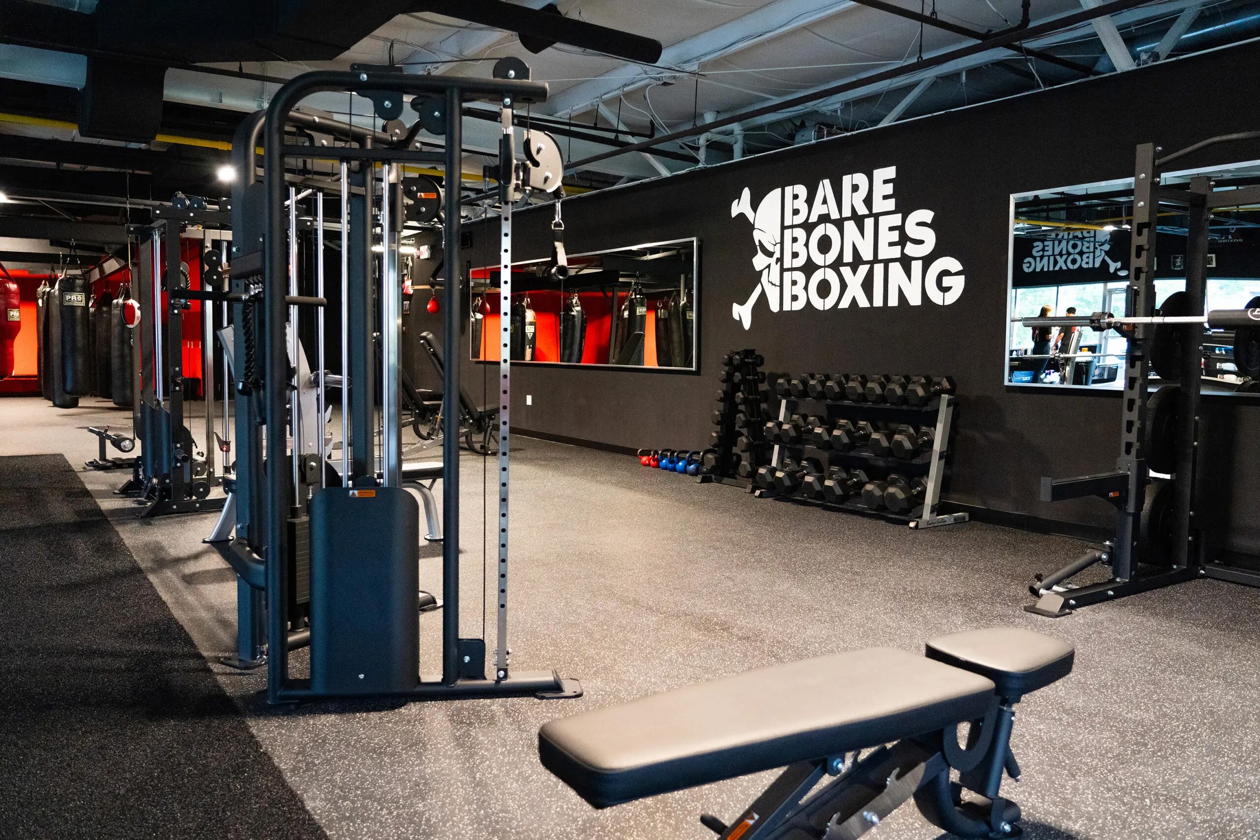 Interior of Bare Bones Boxing gym featuring workout equipment and wall logo designed by Studio Wisdom
