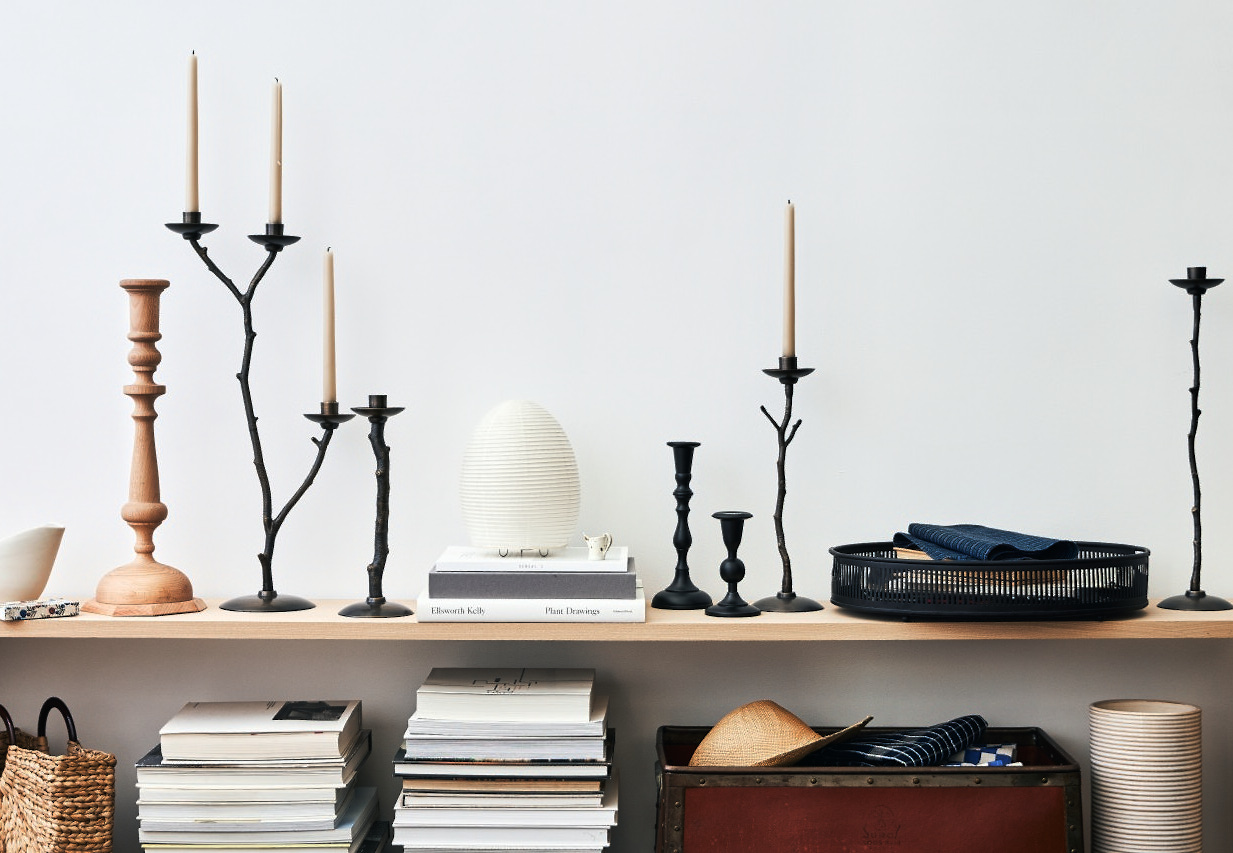 Black candlesticks and pitchers with dramatic shadows on books, styled for Thomas O’Brien Accessories with Studio Wisdom