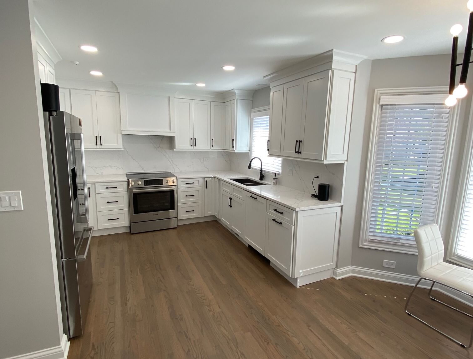 Backyard patio with a wooden pergola, ceiling fan, and built-in outdoor kitchen.