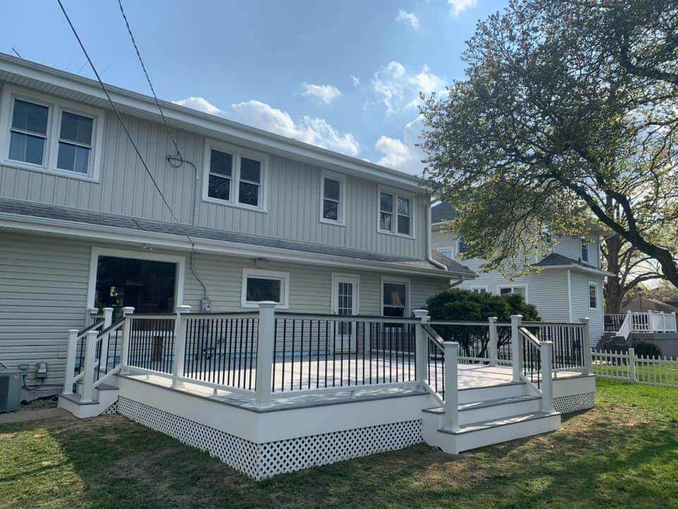 Backyard patio with a wooden pergola, ceiling fan, and built-in outdoor kitchen.
