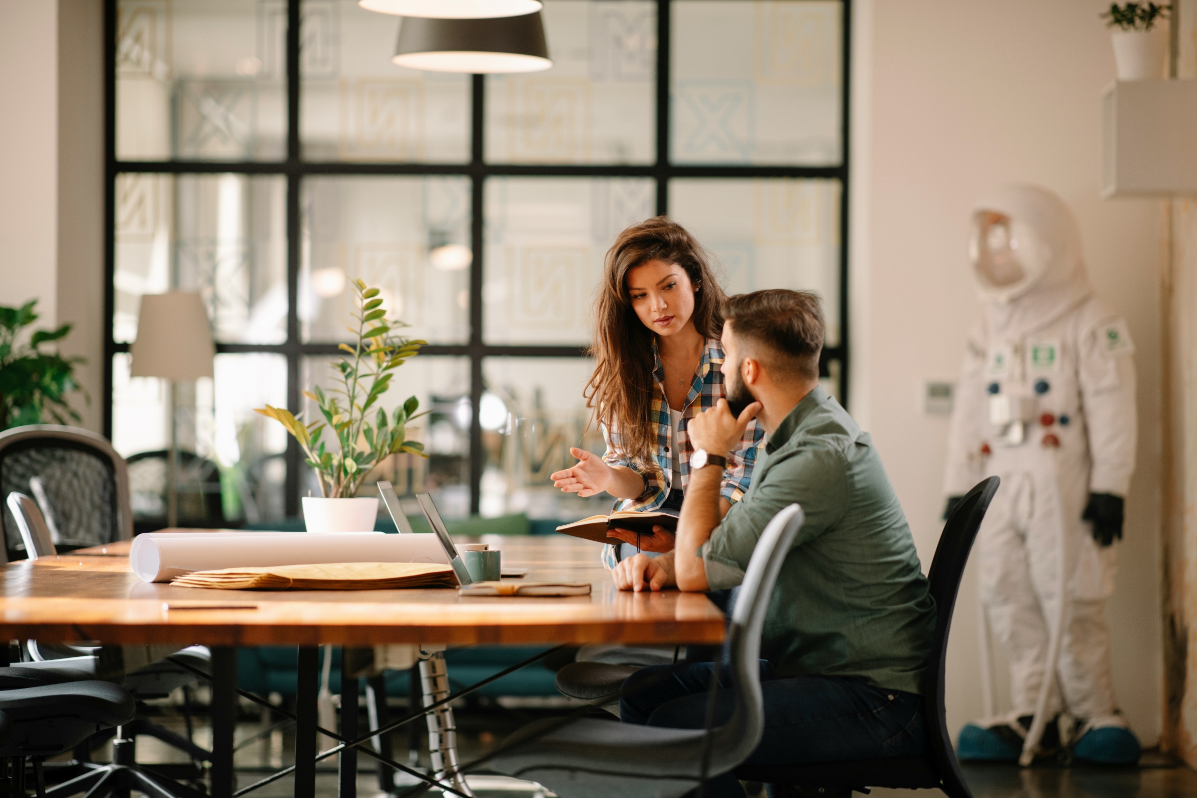 Photo of two people talking during a meeting.