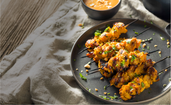 Vérifier les brochettes de satay sur un plat.