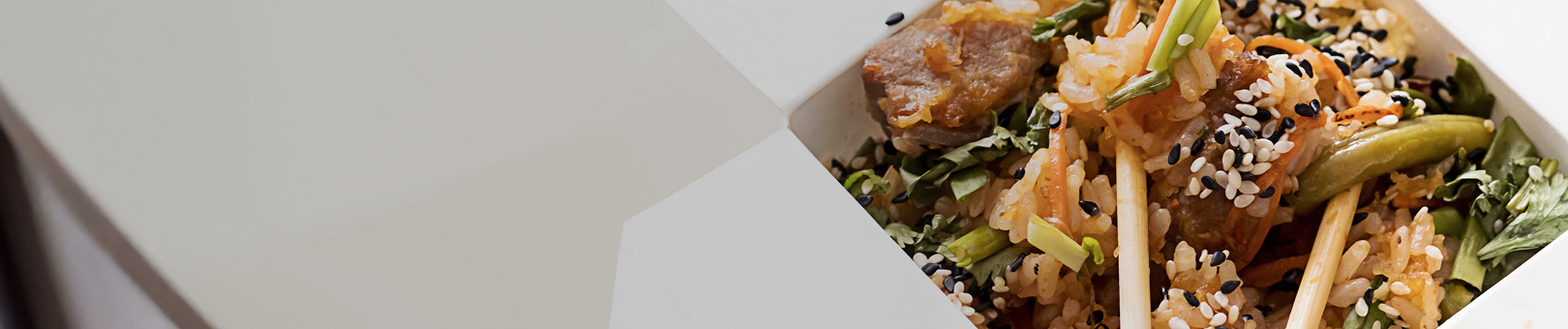 Gros plan d'une boîte à emporter remplie de riz sauté, de légumes et de graines de sésame, accompagnée d'un texte indiquant "Choisissez nos sauces spéciales préférées".