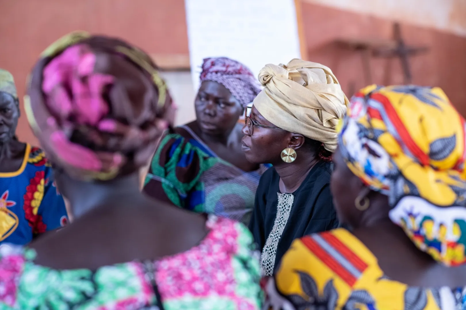 Un groupe de femmes en vêtements colorés  discutent ensemble.