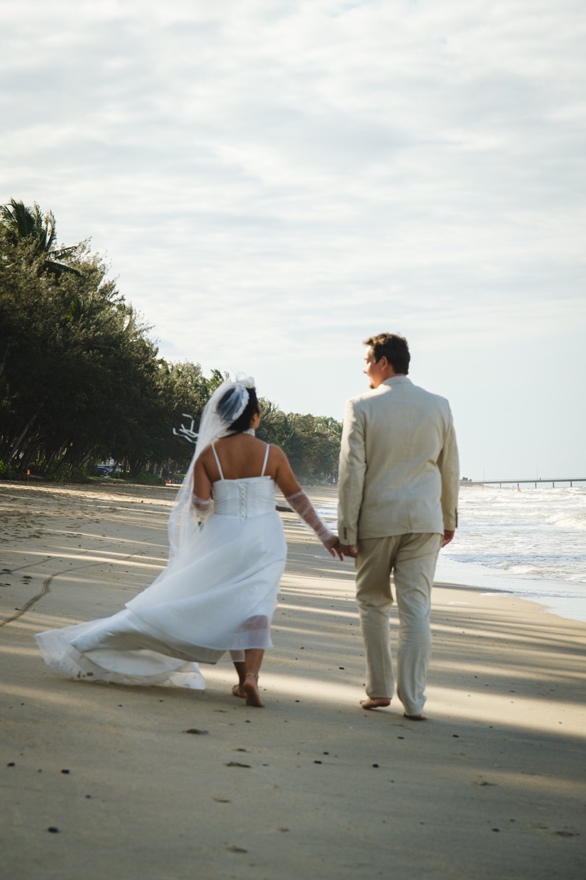 couple from the back walking on the beach in Palm Cove