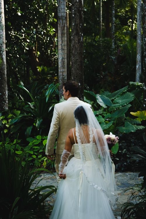 Couple in the rain forest, from the back, wedding style, looking everywhere