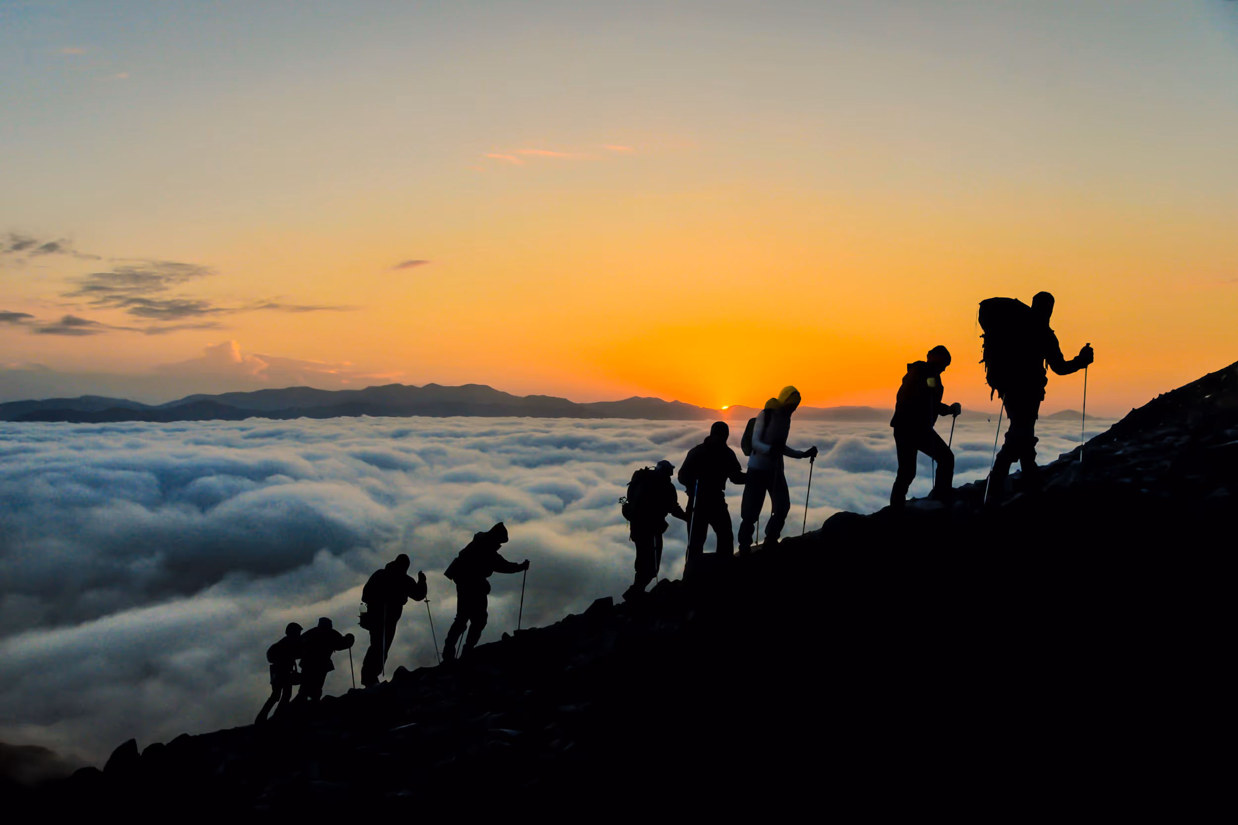 A silhouette of climbers at sunset