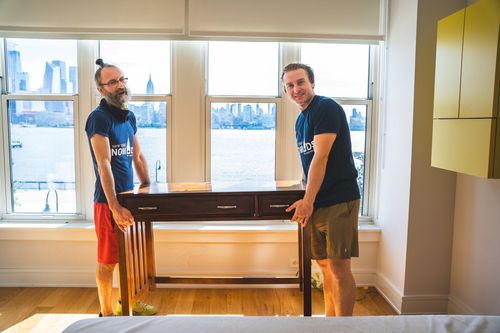 Two man carrying out a table