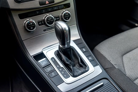 Car automatic transmission gear selector in a modern vehicle interior with a sleek silver and black design.