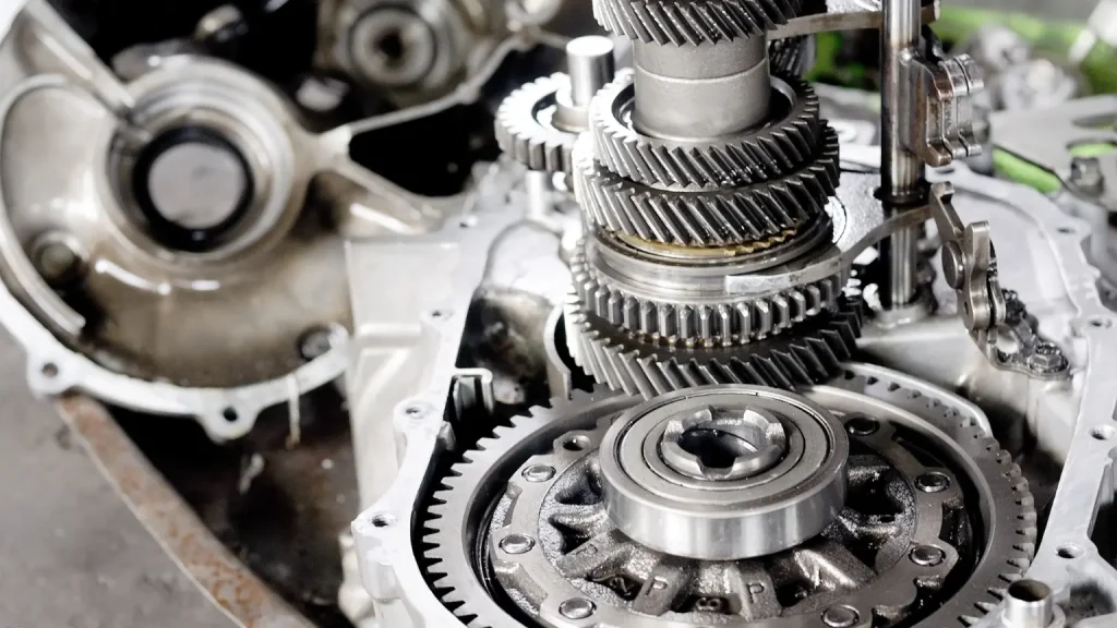 Transmission shop with a partially assembled car transmission system featuring gears and casings