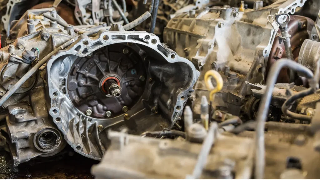 Disassembled car transmission casing showing internal components and gears in a workshop