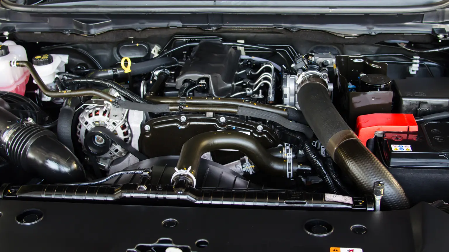Transmission rebuilders showcasing a clean engine bay with visible alternator, pulleys, and fluid reservoirs.