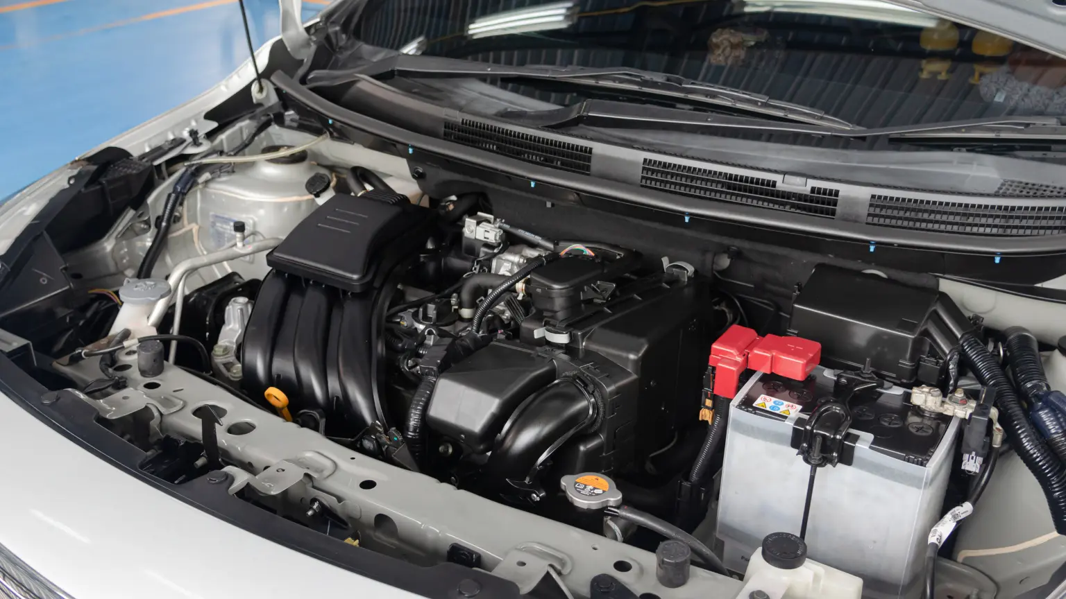 Automatic transmission rebuild engine bay showing battery, intake system, and transmission housing components.