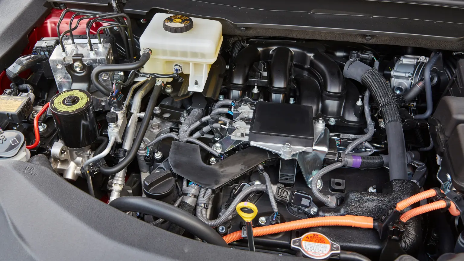 Transmission rebuild labor shown as a mechanic works on a complex engine with various cables and components.