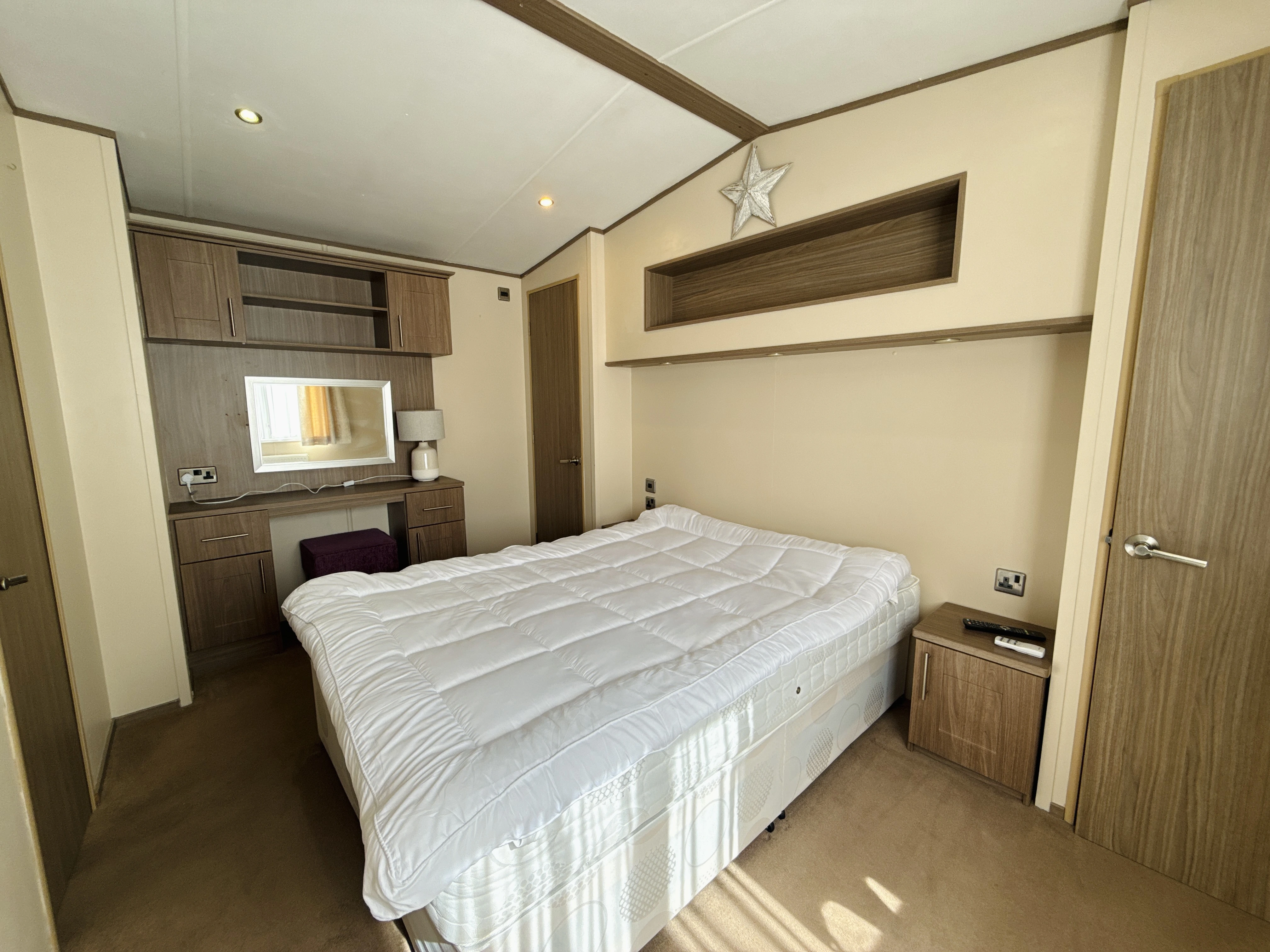 Cozy bedroom with white bedding, wooden furniture, and star wall decor