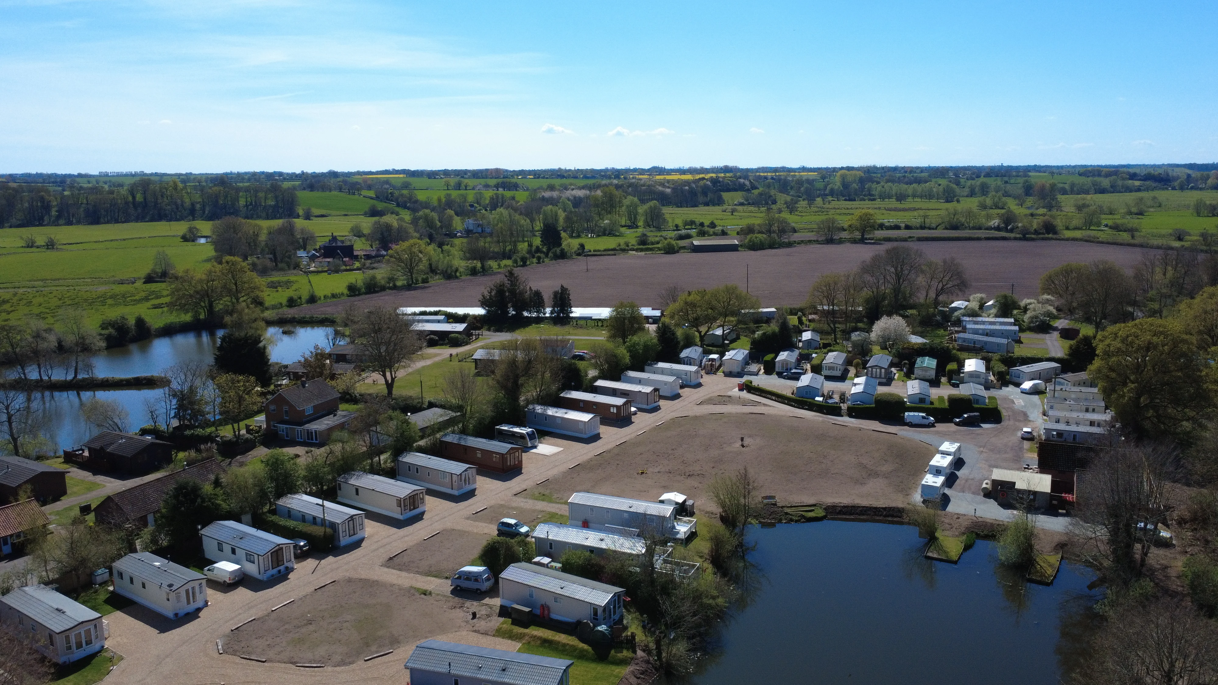 Aerial view of mobile home park with lakes and green countryside