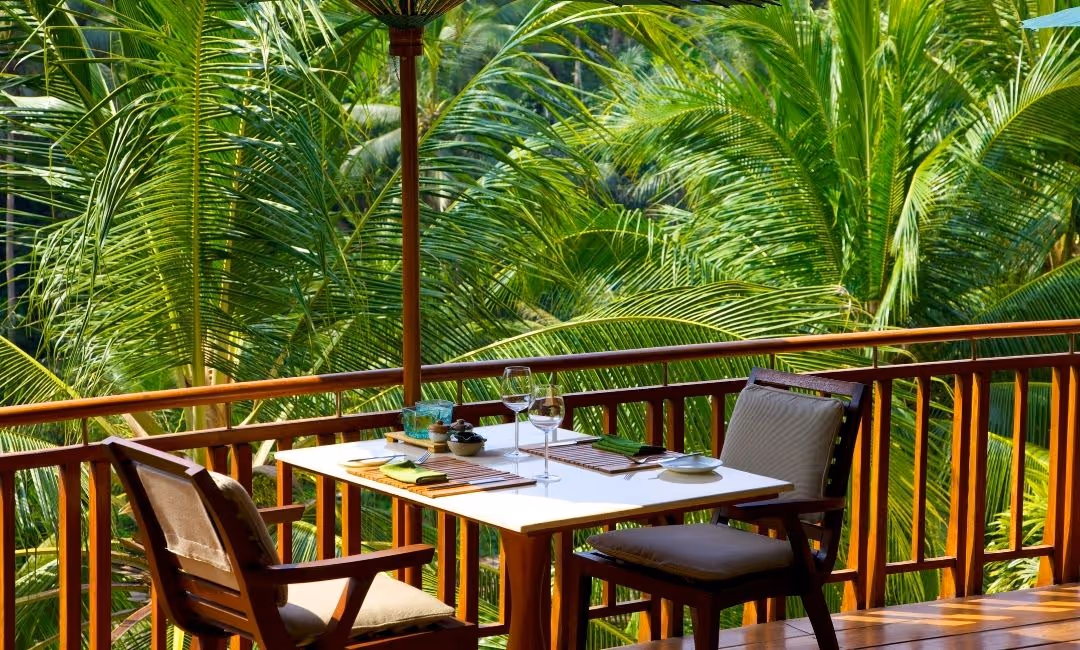 Table for two in a balcony with frontal view of beach palms