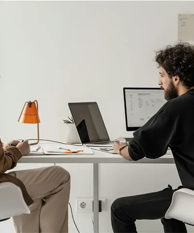 man sitting at desk and looking at laptop