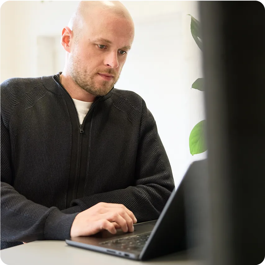 Sergei sitting at desk and looking at laptop