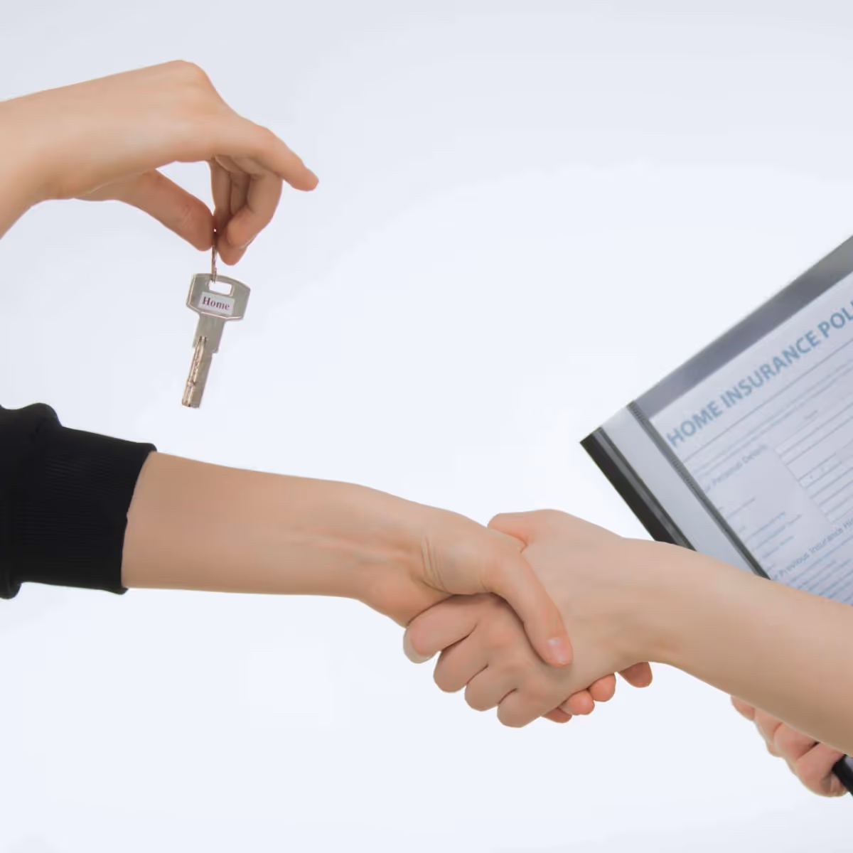 Schlüsselübergabe und Händedruck als Symbol für einen Immobilienversicherungsvertrag.