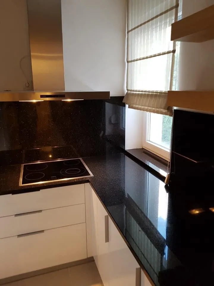 Dibano kur kitchen window nijjo, black sparkling countertop, induction cooktop, netu nāŋi kénné.