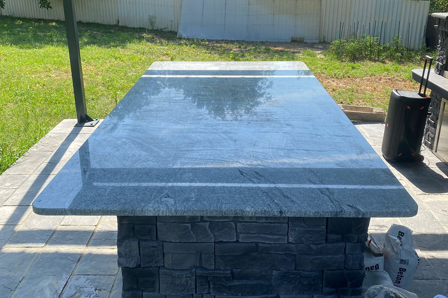 Kameni baštenski sto na terasi sa modernim postoljem