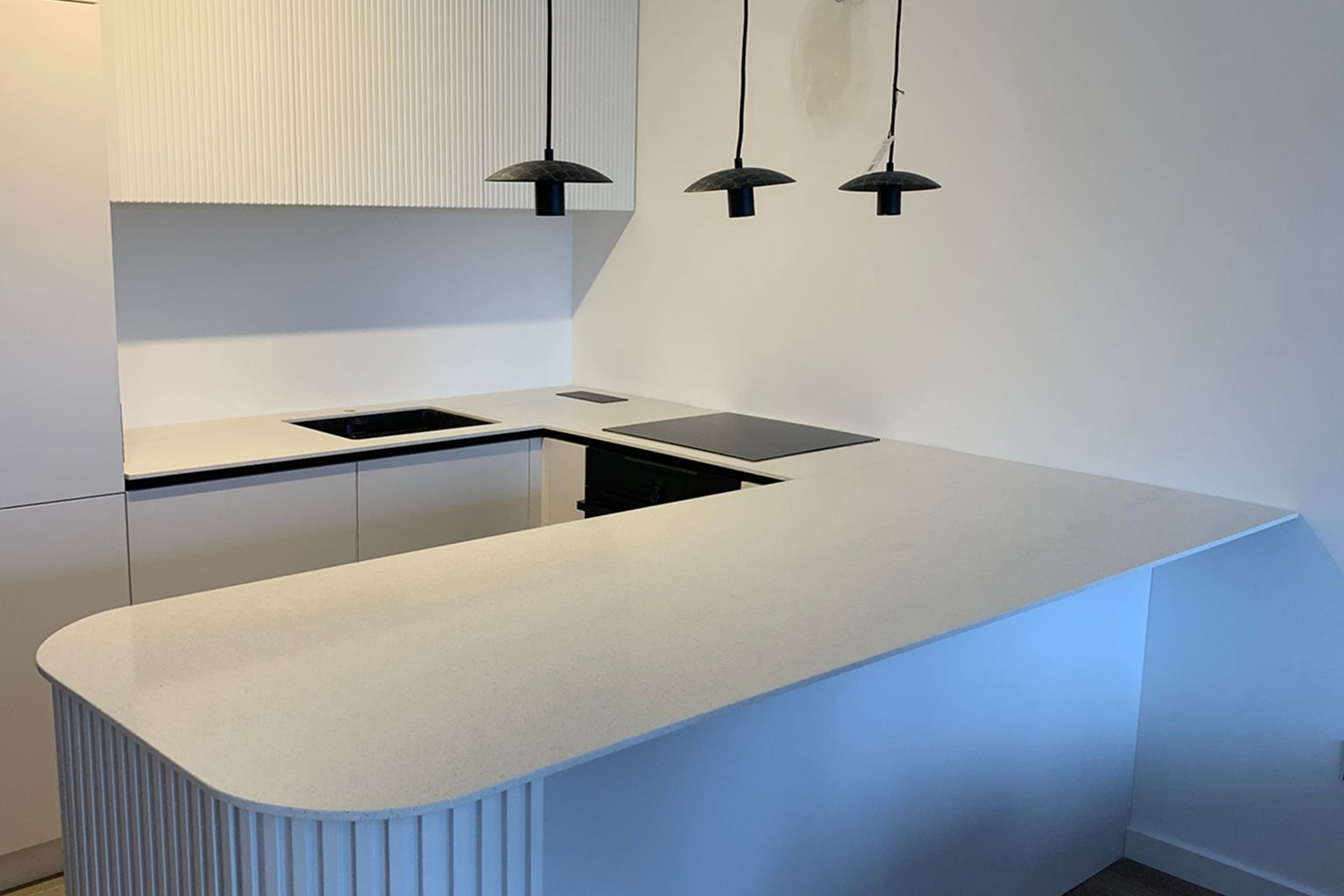 Kvarcna kuhinjska radna ploča u modernoj kuhinji, svetli tonovi i čiste ivice