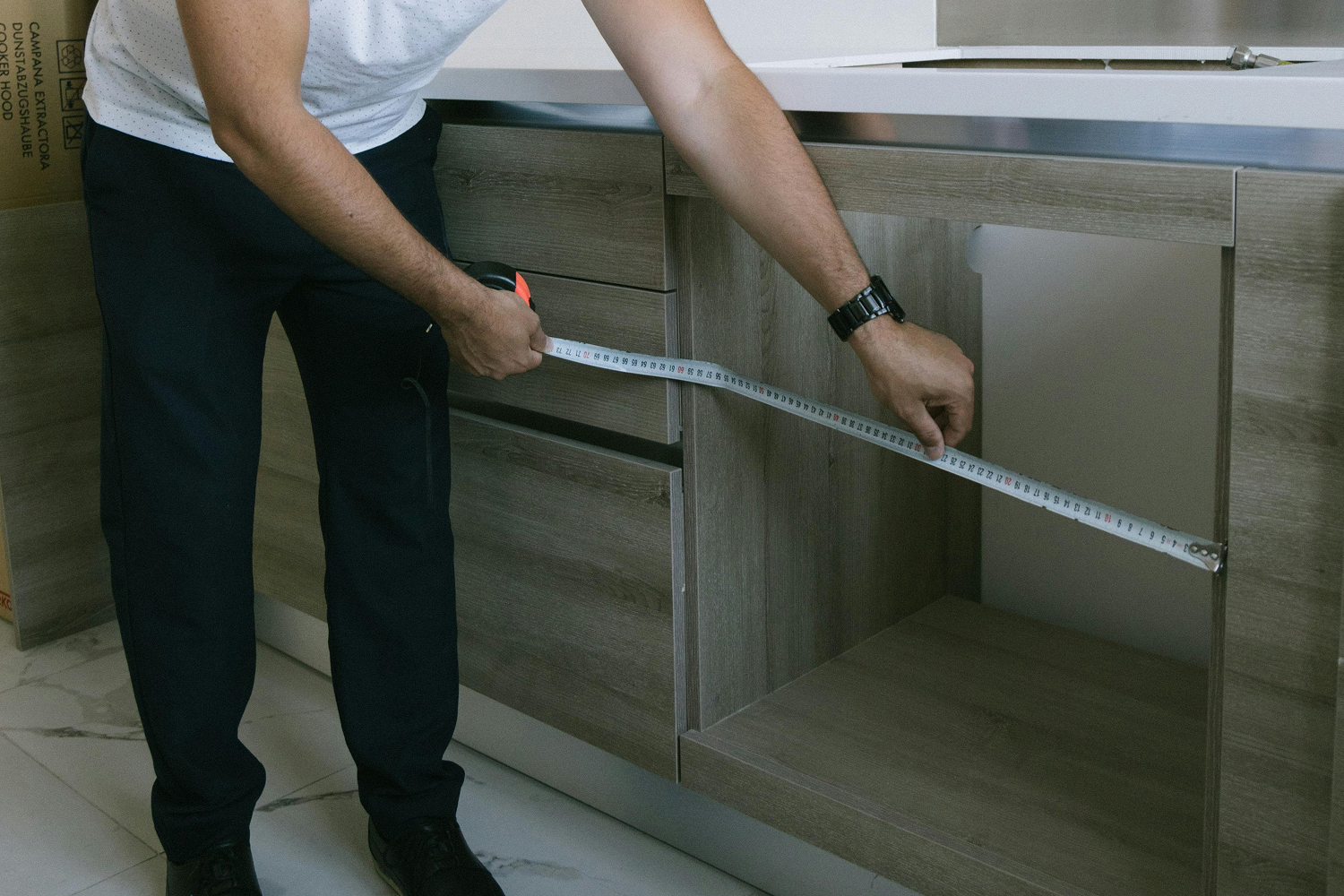 Majstor meri kuhinju laserskim metrom pre ugradnje radne ploče