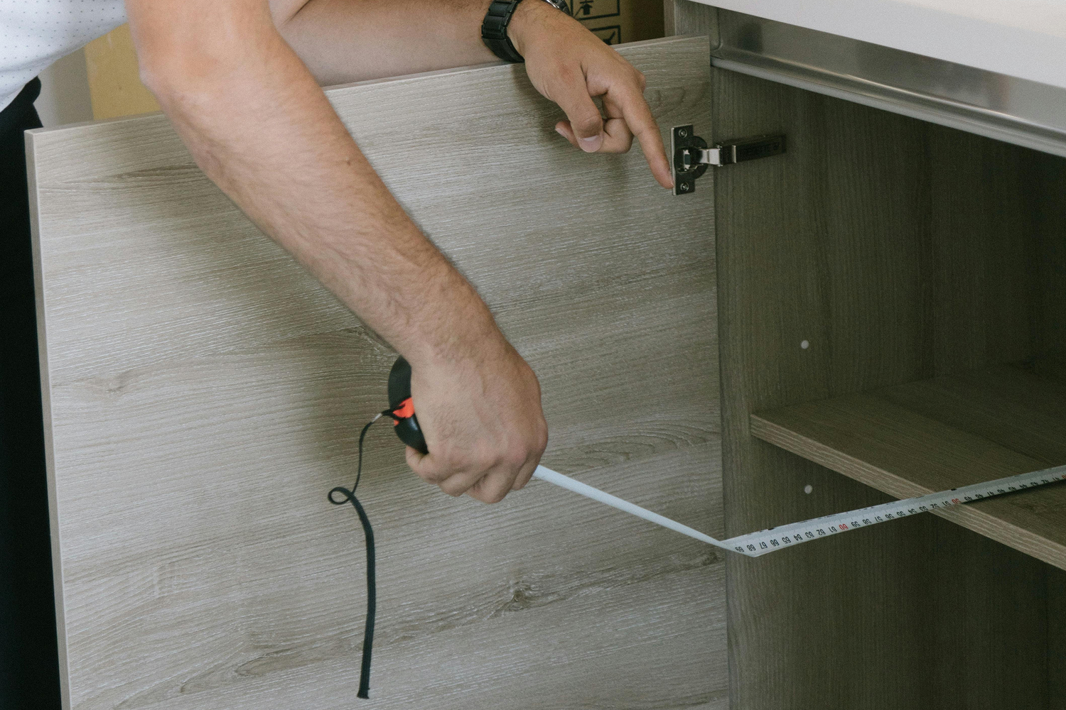 Majstor meri kuhinju laserskim metrom pre ugradnje radne ploče