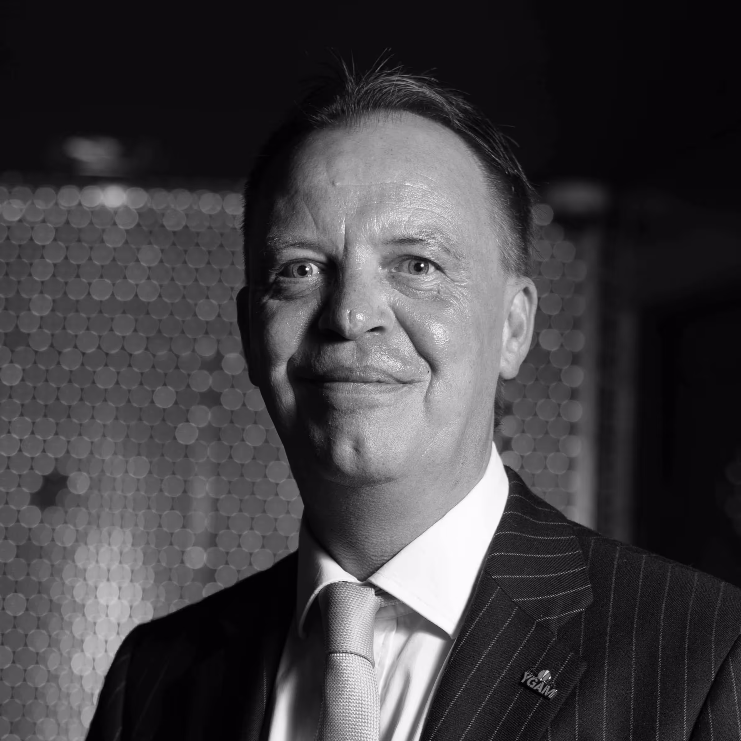 Smiling businessman in pinstripe suit and tie, black and white portrait