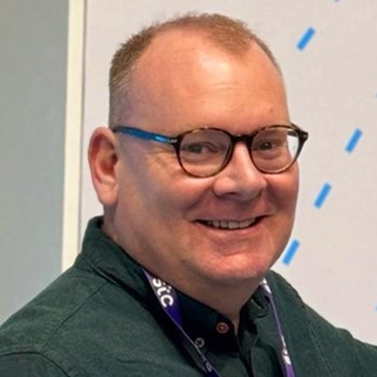 Smiling middle-aged professional in glasses and blue blazer