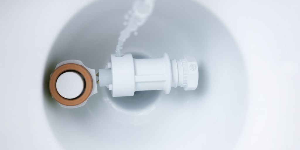 Toilet tank with a leaking flapper valve.